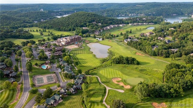 aerial view featuring a view of trees, view of golf course, and a water view
