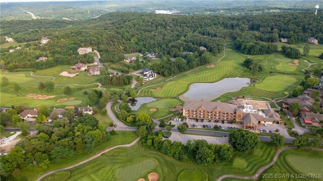 bird's eye view featuring a water view, golf course view, and a wooded view