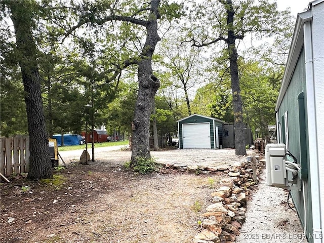 view of yard with fence, an outbuilding, and a detached garage