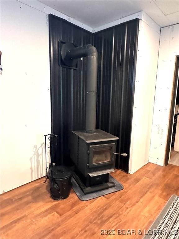 room details featuring a wood stove and wood finished floors