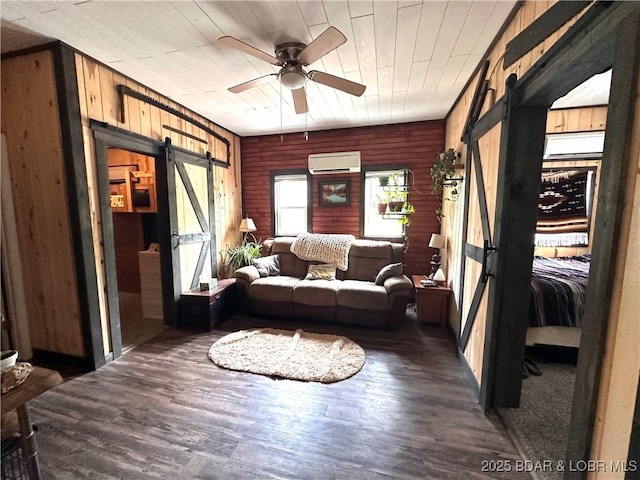 living area featuring wood finished floors, an AC wall unit, a barn door, wood ceiling, and a ceiling fan
