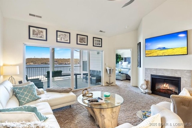 62 Knox Rd Unit 503, Rocky Mount, MO 65072 - living room featuring a tiled fireplace, a ceiling fan, carpet, and visible vents