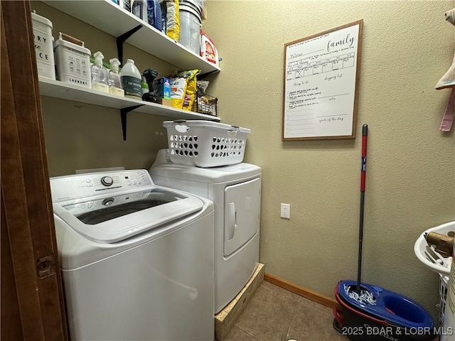laundry room featuring laundry area, tile patterned flooring, baseboards, and washing machine and dryer