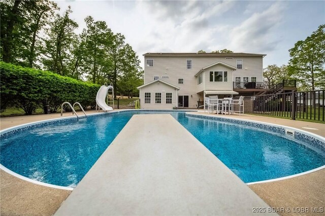 view of swimming pool with a fenced in pool, a water slide, a patio, and fence