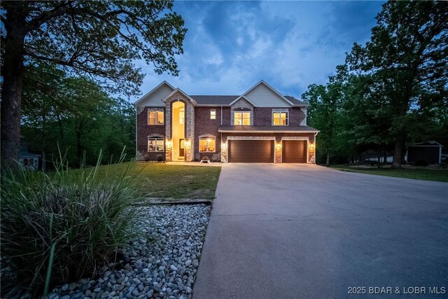 traditional home with an attached garage, a front yard, driveway, and brick siding