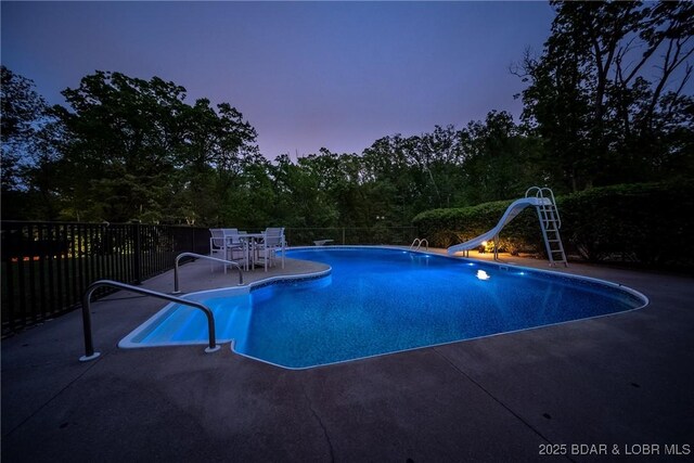 view of swimming pool featuring a fenced in pool, a patio area, and a water slide
