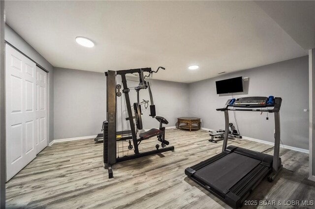 workout area featuring baseboards, recessed lighting, and wood finished floors