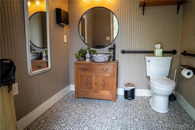 bathroom featuring baseboards, vanity, and toilet