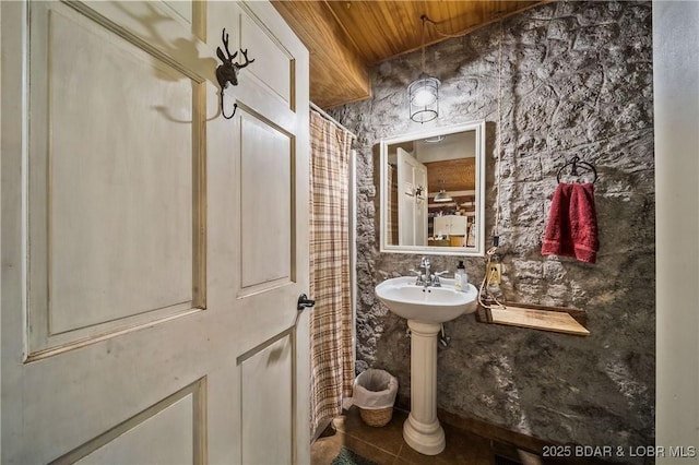 bathroom with wood ceiling, tile patterned flooring, and a sink