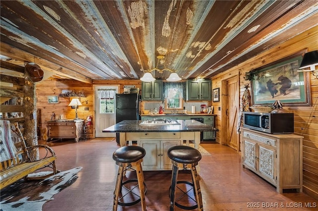 129 Vaughan Rd, Eldon, MO 65026 - kitchen with green cabinets, stainless steel appliances, wood ceiling, wooden walls, and a center island