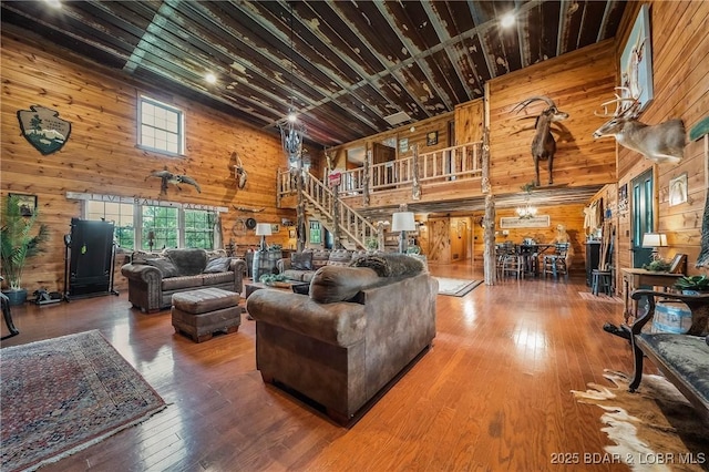 129 Vaughan Rd, Eldon, MO 65026 - living area featuring wooden walls, a high ceiling, hardwood / wood-style floors, and stairway