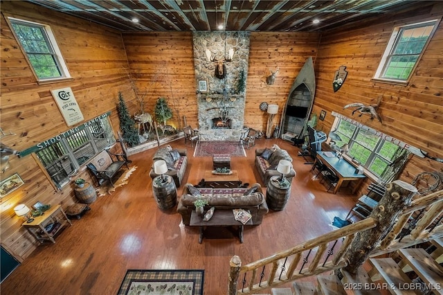 129 Vaughan Rd, Eldon, MO 65026 - living room featuring wooden walls, wood finished floors, and a stone fireplace