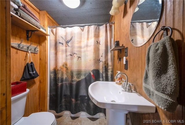 bathroom featuring toilet, a sink, and curtained shower