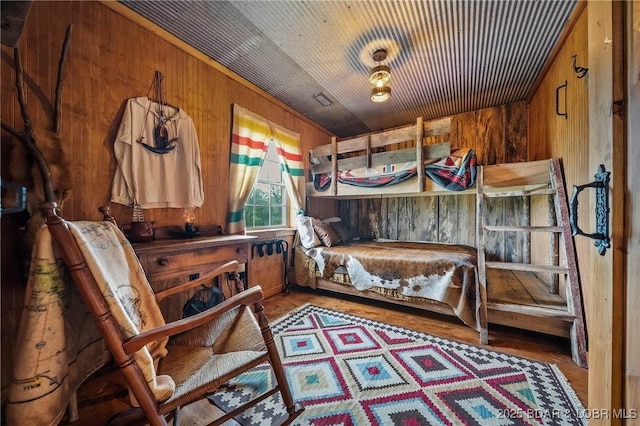 bedroom with wooden walls and wood finished floors