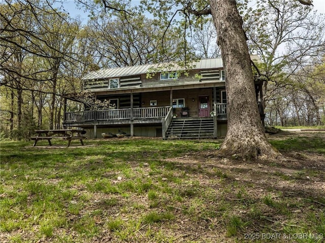 rear view of house with a deck, metal roof, stairway, log exterior, and a standing seam roof