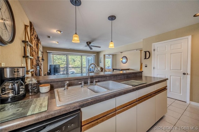 kitchen with white cabinets, dark countertops, hanging light fixtures, a sink, and black dishwasher