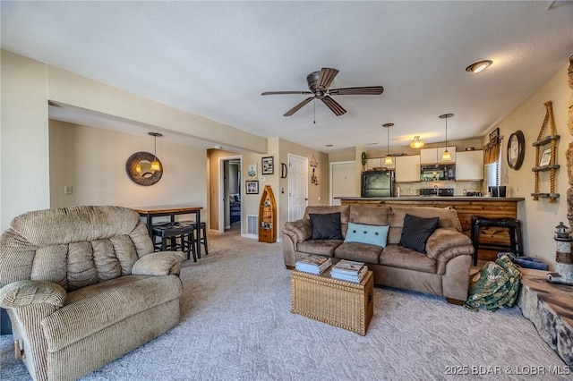 carpeted living area featuring a ceiling fan