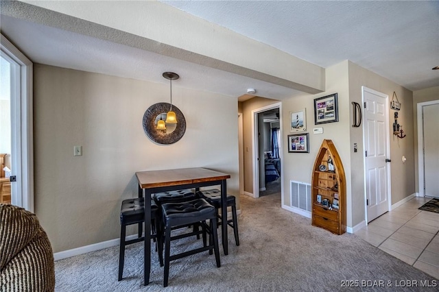 carpeted dining space with baseboards and visible vents