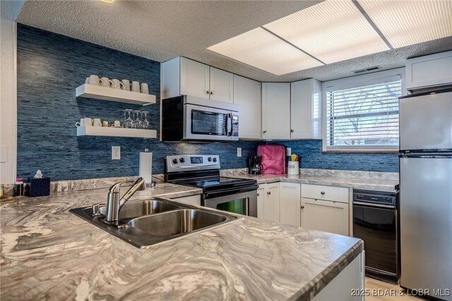 256 Lone Oak Pt Unit 15, Sunrise Beach, MO 65079 - kitchen with open shelves, a sink, light countertops, white cabinets, and stainless steel appliances