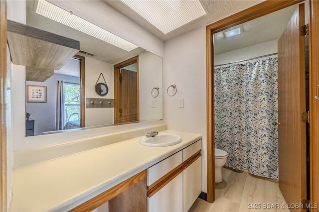 256 Lone Oak Pt Unit 15, Sunrise Beach, MO 65079 - bathroom featuring vanity, toilet, a shower with shower curtain, wood finished floors, and visible vents