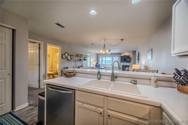 kitchen featuring a sink, light countertops, open floor plan, and dishwasher