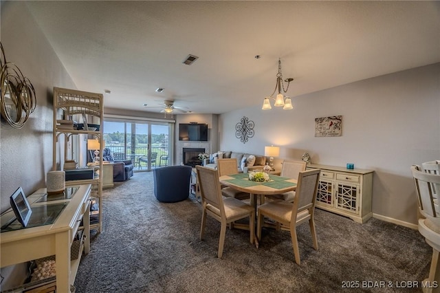dining area featuring a fireplace, ceiling fan, carpet, and visible vents
