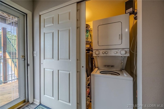 washroom with stacked washer and dryer and laundry area