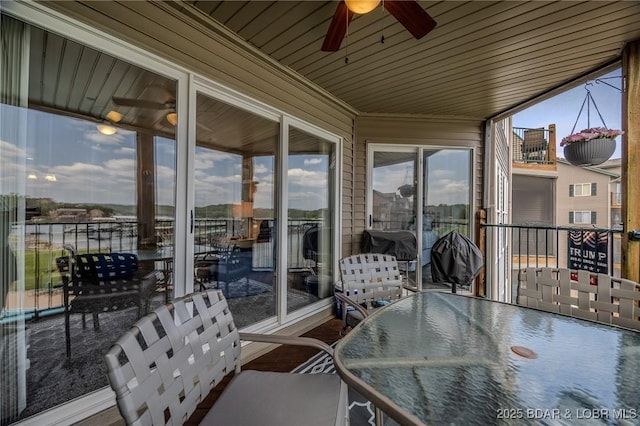 sunroom / solarium featuring outdoor dining area and ceiling fan