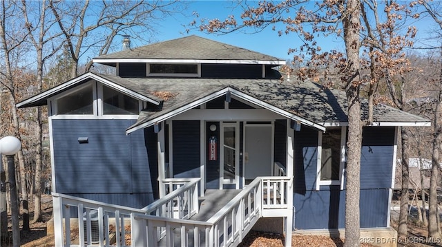 view of front of property with a shingled roof and covered porch