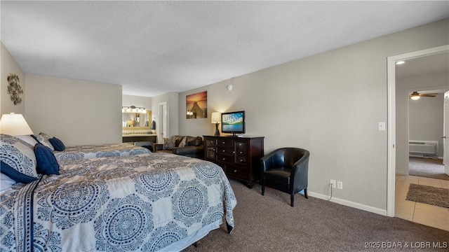 bedroom featuring a textured ceiling, baseboards, an AC wall unit, connected bathroom, and carpet