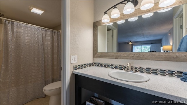 bathroom featuring vanity, a textured wall, toilet, tile patterned floors, and a ceiling fan