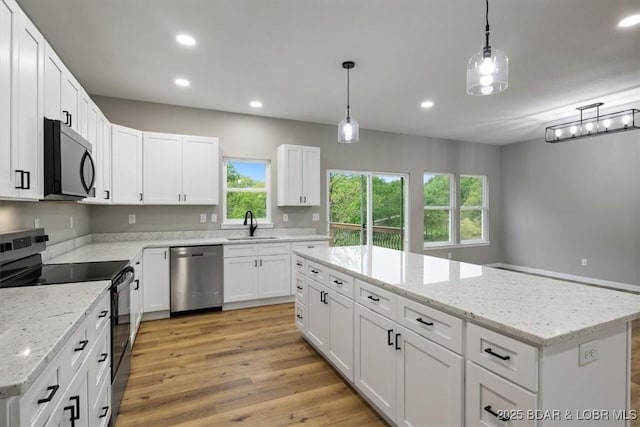 21 Meadow Lake Cir, Eldon, MO 65026 - kitchen with appliances with stainless steel finishes, a kitchen island, recessed lighting, light wood-type flooring, and pendant lighting