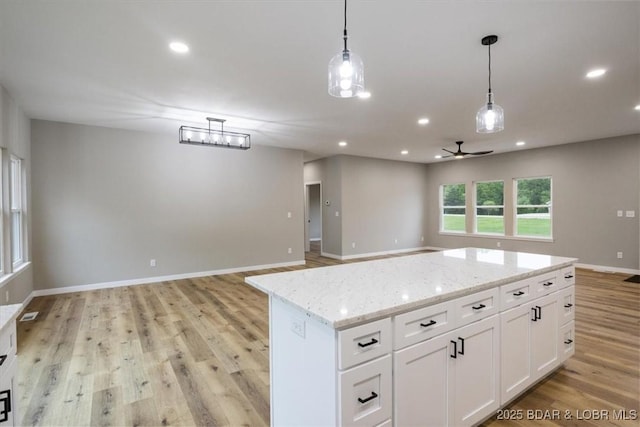 21 Meadow Lake Cir, Eldon, MO 65026 - kitchen featuring open floor plan, light wood-type flooring, white cabinets, pendant lighting, and recessed lighting