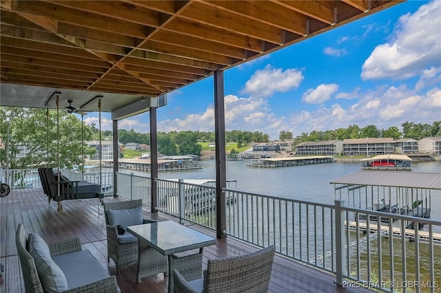 wooden deck featuring a water view, a dock, and boat lift