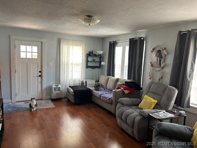 living room with a textured ceiling, wood finished floors, and a wealth of natural light