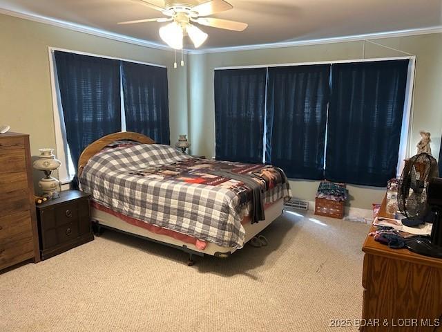 bedroom featuring carpet flooring, a ceiling fan, and ornamental molding