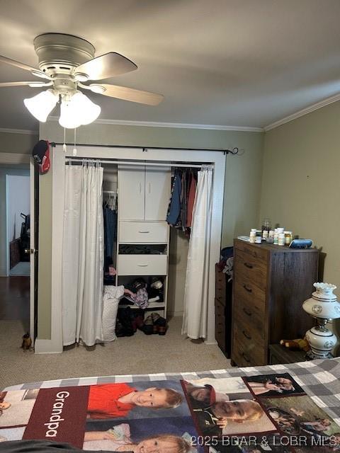carpeted bedroom with a ceiling fan and ornamental molding