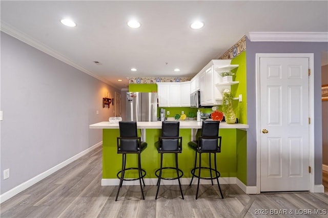 768 Clearwater Dr Unit 2-A, Camdenton, MO 65020 - kitchen featuring stainless steel appliances, white cabinets, light countertops, a peninsula, and crown molding