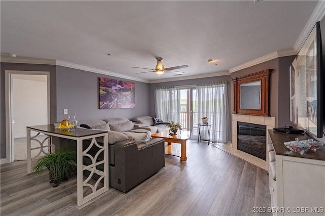 768 Clearwater Dr Unit 2-A, Camdenton, MO 65020 - living room with ceiling fan, wood finished floors, a tiled fireplace, and ornamental molding