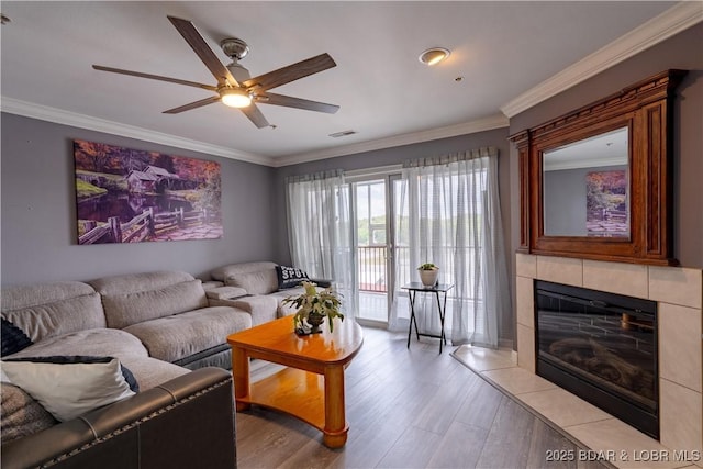 768 Clearwater Dr Unit 2-A, Camdenton, MO 65020 - living area with light wood-style floors, a ceiling fan, ornamental molding, and a tiled fireplace
