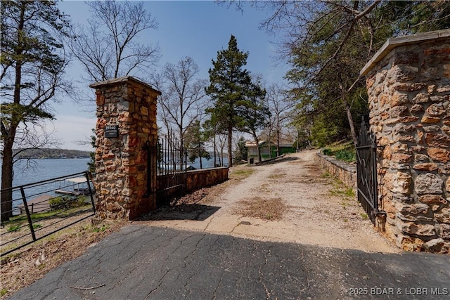 29540 Inspiration Pt, Rocky Mount, MO 65072 - view of street with a gate, dirt driveway, a water view, and a gated entry