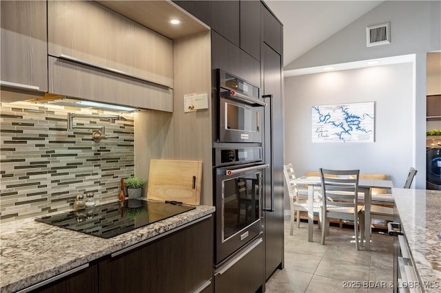 56 Treasure Cay, Osage Beach, MO 65065 - kitchen featuring tasteful backsplash, black electric stovetop, lofted ceiling, light stone countertops, and modern cabinets