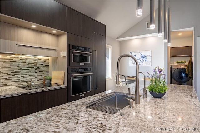 kitchen with dark brown cabinetry, a sink, black electric cooktop, decorative backsplash, and vaulted ceiling
