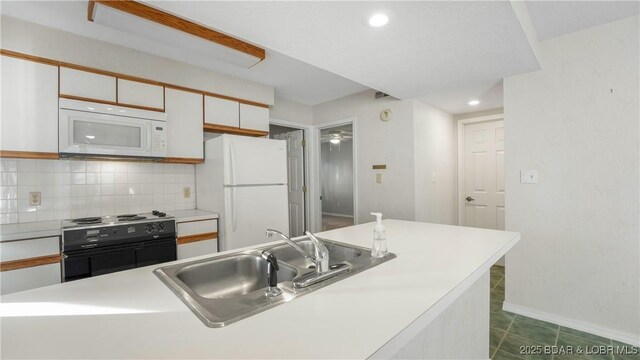 67 Ventura Dr Unit 427, Lake Ozark, MO 65049 - kitchen with backsplash, a sink, light countertops, white appliances, and white cabinetry