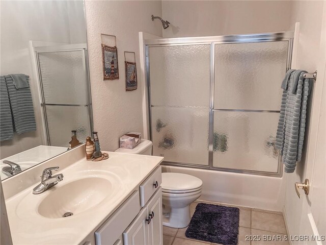 full bathroom with vanity, tile patterned flooring, enclosed tub / shower combo, and toilet