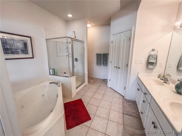 bathroom with double vanity, a shower stall, a sink, tile patterned floors, and a whirlpool tub