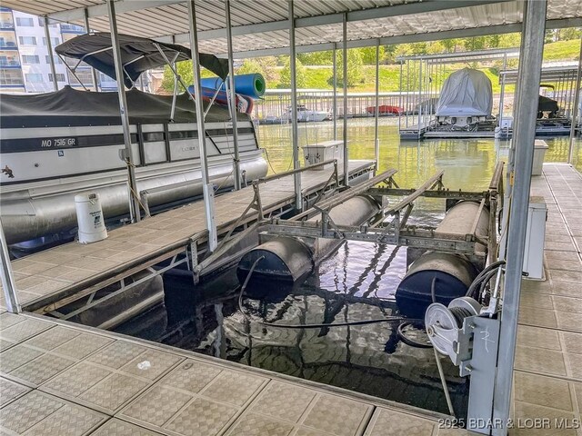 view of dock with boat lift and a water view