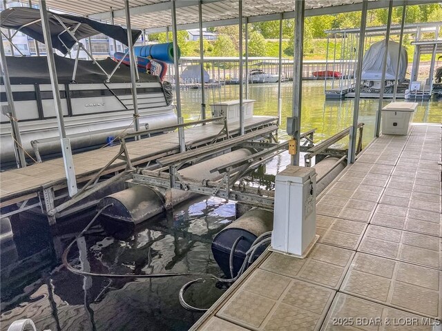 view of dock with boat lift and a water view