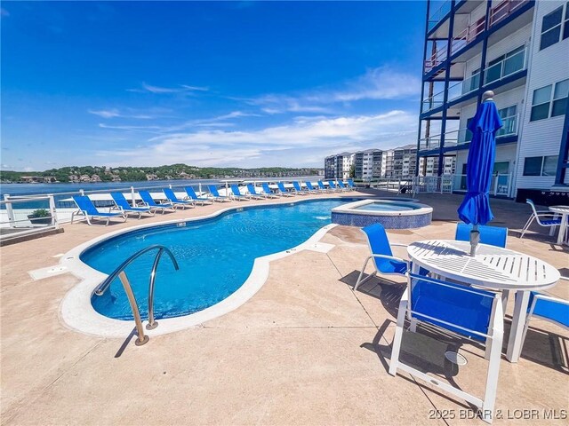 view of swimming pool with a pool with connected hot tub and a patio area