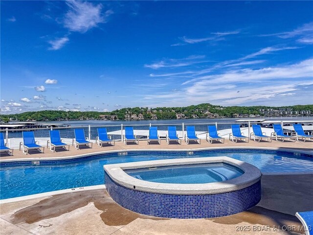 view of pool with a pool with connected hot tub